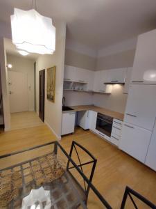 a kitchen with white cabinets and a table in a room at Sulkowicka Apartment in Warsaw