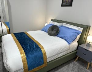 ein Schlafzimmer mit einem Bett mit blauen Kissen in der Unterkunft Aqua Dream Luxury Apartment-Coyles Place at Portland 88 in Belfast