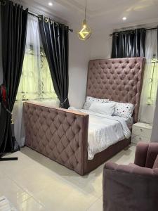 a large bed in a bedroom with black curtains at 2 bedroom Diva's Exquisite Apartment in Lekki