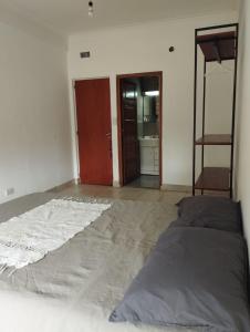 an empty room with a bed and a bathroom at Habitación privada en residencia CENTRO-NQN, baño ensuite in Neuquén