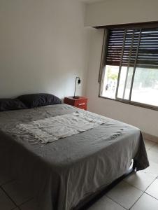 a bedroom with a large bed with a window at Habitación privada en residencia CENTRO-NQN, baño ensuite in Neuquén
