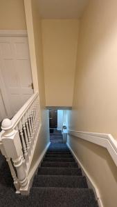 a winding staircase in a building with a white door at The Cosy Beech in Lisnaskea