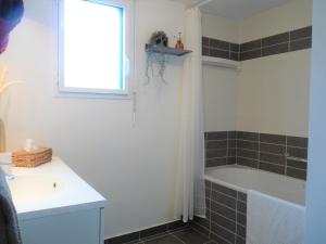 a bathroom with a tub and a sink and a window at Le GLAZ * Grande plage & commerces à pied * Jardin in Carnac +22 photos