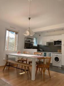 a kitchen with a table and chairs in a room at Le GLAZ * Grande plage & commerces à pied * Jardin in Carnac