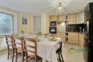 a dining room with a table and a kitchen at Au charme des bois in Plouhinec