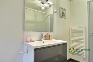 a bathroom with a white sink and a mirror at Au charme des bois in Plouhinec +19 photos