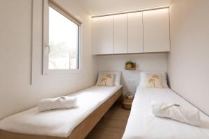 En eller flere senge i et værelse på Meditandia - Premium Mobile House