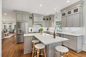 a kitchen with white cabinets and a island with bar stools at 18 Ocean Green in Kiawah Island