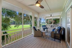a screened in porch with chairs and a table at 18 Ocean Green in Kiawah Island