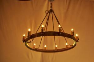 a chandelier with candles in a room at Tall Trees Glamping in Baltonsborough