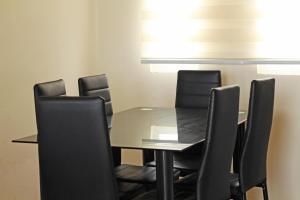 a conference room with a glass table and black chairs at Entre Dunas y Caracolas in Punta de Choros