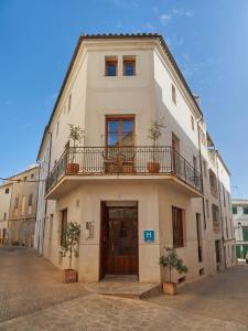 - un bâtiment blanc avec un balcon au-dessus dans l'établissement Petit Hotel Forn Nou, à Artà