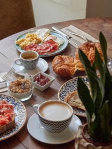 uma mesa coberta com pratos de pequeno-almoço e café em Petit Hotel Forn Nou em Artá