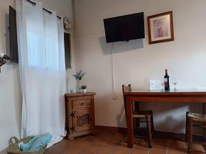 a room with a desk and a television and a table at Las Casitas de Higuera in Higuera de la Sierra