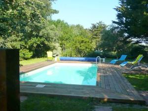 een zwembad met een terras en stoelen eromheen bij Fenetres sur le golfe in Sarzeau