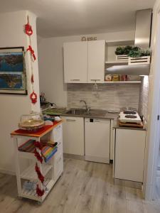 a kitchen with white cabinets and a sink at La Finestra sul Lago in Brusimpiano