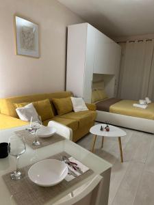 a living room with a couch and a table with wine glasses at Sindi's Daily Apartment in Durrës