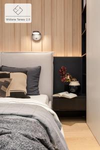 - une chambre avec un lit et une table avec une plante dans l'établissement Wiślane Tarasy Apartment, à Cracovie