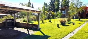 einen Garten mit einem Pavillon und einem Gebäude in der Unterkunft Los Coirones in Potrerillos