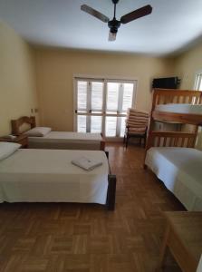 1 dormitorio con 3 camas y ventilador de techo en HOTEL BATOVI en São Gabriel