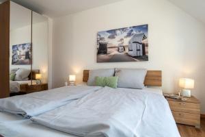 uma grande cama branca num quarto com 2 candeeiros em Strandpark-Grossenbrode-Haus-Windrose-Wohnung-13 em Grossenbrode