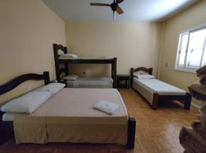 a bedroom with two beds and a ceiling fan at HOTEL BATOVI in São Gabriel