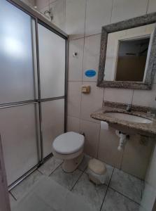 a bathroom with a toilet and a sink and a mirror at HOTEL BATOVI in São Gabriel