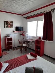 a room with a bed and a desk and a window at MAISON D HÔTES Marine KSAR SGHIR in Ksar es Sghir