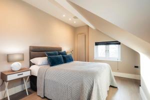 sypialnia z łóżkiem z niebieskimi poduszkami w obiekcie Hampstead Luxury Flat-Hosted by Sweetstay w Londynie