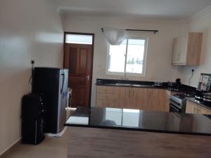 a kitchen with a black refrigerator and a window at 2BR Shanzu Serena in Mombasa