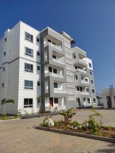 a large white apartment building in a parking lot at 2BR Shanzu Serena in Mombasa
