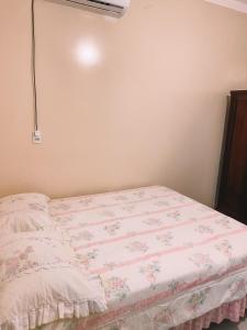 1 dormitorio con 1 cama con edredón rosa y blanco en Casa em Penha, en Penha