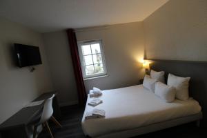 a hotel room with a bed and a window at Hôtel Casabianca in Moulins