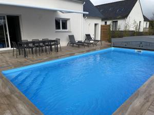 een groot blauw zwembad voor een huis bij De l'ocean in Le Tour-du-Parc