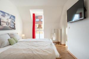 um quarto branco com uma cama grande e uma janela em Strandpark-Grossenbrode-Haus-Windrose-Wohnung-13 em Grossenbrode