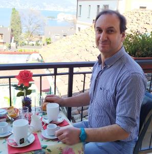 a man sitting at a table with coffee cups at Casa Nicolò in Stresa