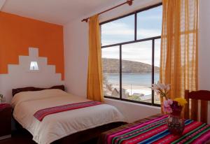 a bedroom with a bed and a large window at Hostal Margarita Isla del Sol Norte comunidad Challapampa in Comunidad Challapampa