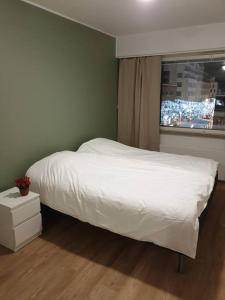 - une chambre avec un lit blanc et une fenêtre dans l'établissement Huoneisto Rovakatu 27 A7, à Rovaniemi