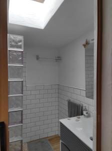 a bathroom with a sink and a white tiled wall at Casa las montañas de Anaga in Las Lagunas