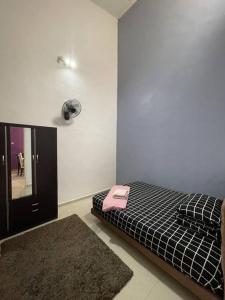 um quarto com uma cama com um telefone rosa em Homestay ShimahJay Telok Mas Melaka em Malaca