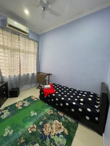 a bedroom with a bed with a flower pattern on it at Homestay ShimahJay Telok Mas Melaka in Melaka