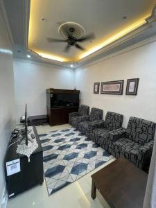 uma sala de espera com sofás, uma mesa e uma televisão em Homestay ShimahJay Telok Mas Melaka em Malaca