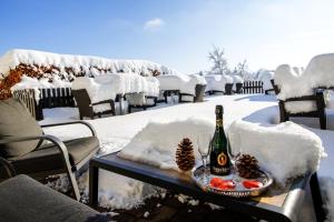 een fles champagne en fruit op een tafel in de sneeuw bij Hotel Sonnenhang in Kempten