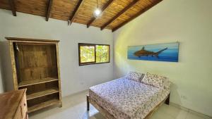 ein Schlafzimmer mit einem Bett und einem Fenster in einem Zimmer in der Unterkunft Casa Beira Mar in Ilhabela