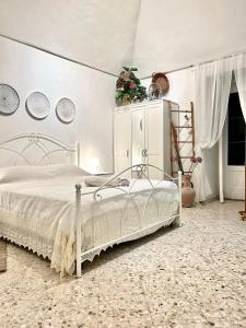 a bedroom with a white bed and a white cabinet at DIMORA ELIVA in Monopoli