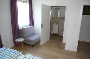 ein Wohnzimmer mit einem Stuhl und ein Badezimmer in der Unterkunft Apartment Moni in Lutzmannsburg, 1 km von der Sonnentherme entfernt - Apartment mit 3 Schlafzimmern in Lutzmannsburg