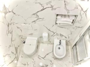 a white bathroom with a toilet and a bidet at Perugia Family Flat in Perugia +39 photos