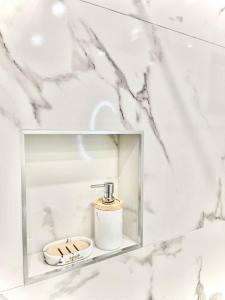 a bathroom with a soap dispenser in a glass box at Perugia Family Flat in Perugia
