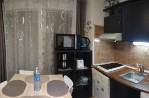 eine kleine Küche mit einem Tisch und einem Waschbecken in der Unterkunft Residence EDEN - 300m de la mer , parking privatif inclus in Juan-les-Pins