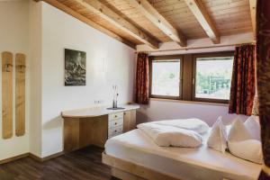 1 dormitorio con cama, lavabo y ventana en Thalguter - Rooms & Breakfast, en Lagundo